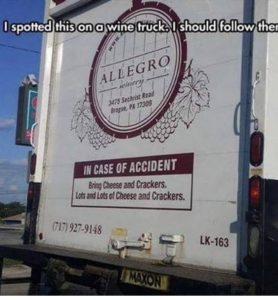 The back of a wine truck. A sign says, "In case of emergency, bring cheese and crackers. Lots of cheese and crackers." An image caption at the top says: "I spotted this on a wine truck. I should follow them."