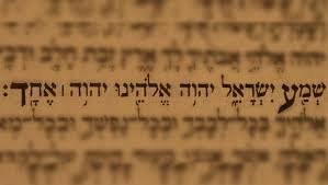 An image of Hebrew text blurred except for a clearly written Shema prayer in Hebrew