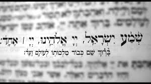 Blurred Hebrew text with clearly written Shema Prayer in the middle