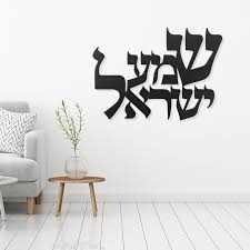 A white room with a chair and Shema Israel written in Hebrew on the wall